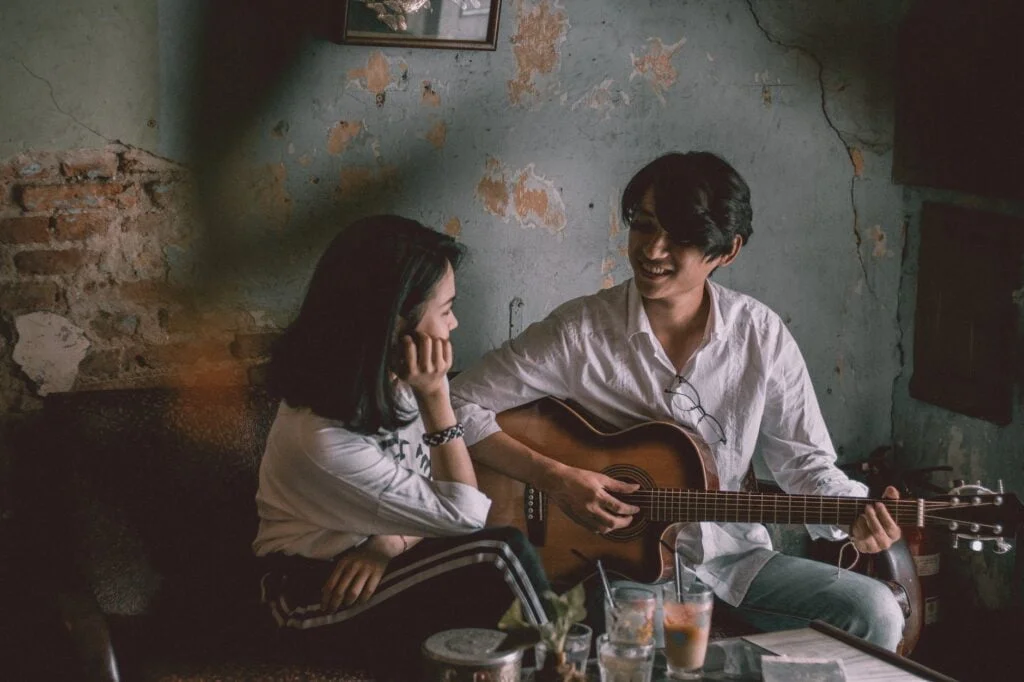 Miten parantaa parisuhdetta? man playing guitar with girl