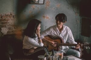 Photo by Mẫnn Quang on <a href="https://www.pexels.com/photo/man-playing-guitar-with-girl-3450887/" rel="nofollow">Pexels.com</a>